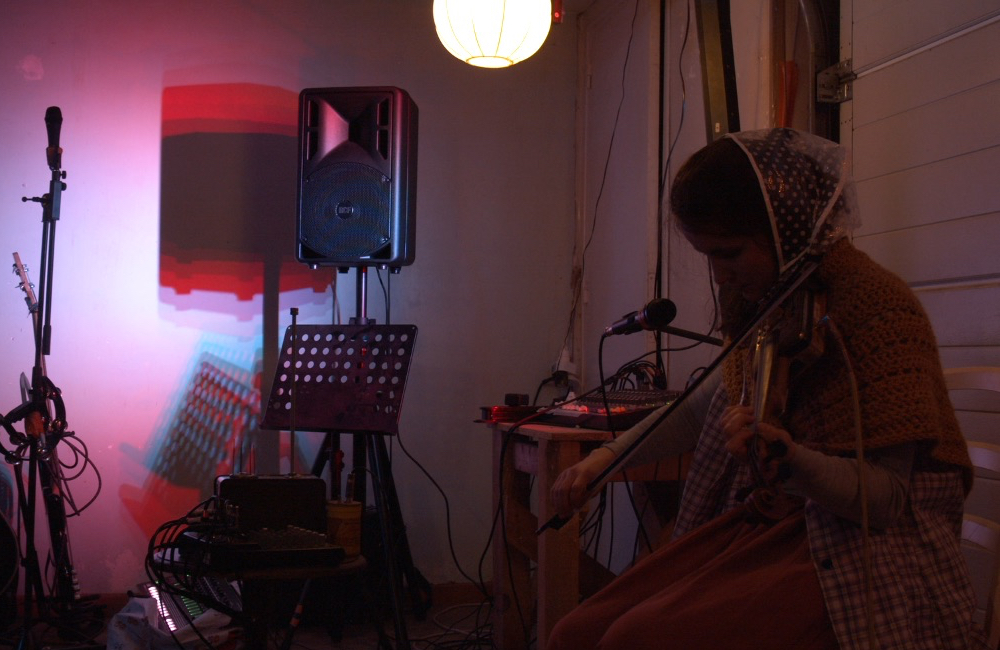 Mamilena jouant du violon, des personnes dansent